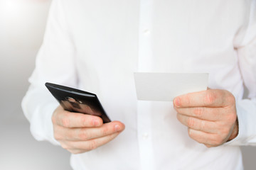 Business man holding a callingcard and a mobile calling customer service. Empty copy space for Editor's text