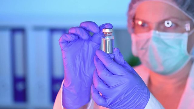 Doctor and nurse analyzing unknown MMR vaccine in medical clinic hospital