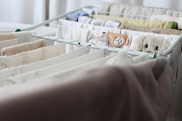 Clothes drying rack full of clothes and napkins for a newborn baby
