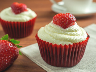 Close-up image of red velvet strawberry cup cake on coffee cup background with copy space, Valentine concept