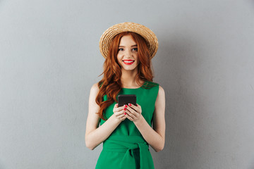 Redhead young happy woman chatting by mobile phone.