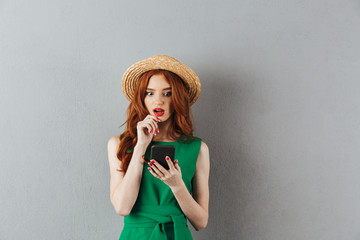 Redhead young shocked confused woman chatting by phone.