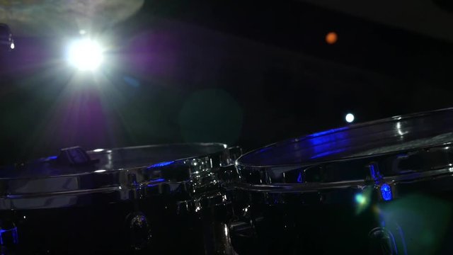 Close-up of a drummer's hands while playing drums live performance rock band, the drummer's hands playing on stage at the rays of light concert