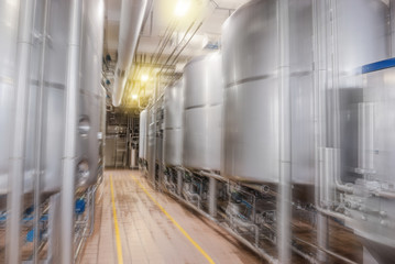 Large stainless steel barrels connected by pipes in the factory industry. Motion blur abstract background