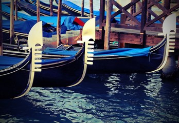 Fototapeta na wymiar Venetian gondolas moored in landing passengers with vintage effect