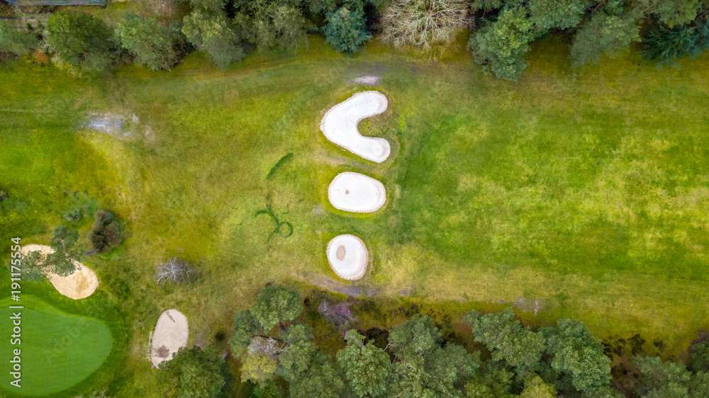 Poster Drone view of a golf course with colorful trees and a beautiful surrounding nature