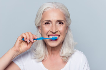 Concept of cleaning teeth is a correct way. Close up photo of happy cheerful mature old lady with...
