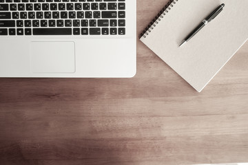 Top view of a laptop with a diary. Pen on wood table In the view of the working table