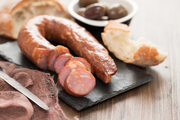 smoked sausages with bread on black ceramic board