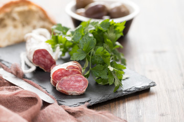 Traditional Spanish sausage Fuet on black ceramic background