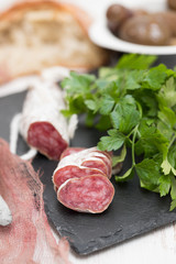 Traditional Spanish sausage Fuet on black ceramic background