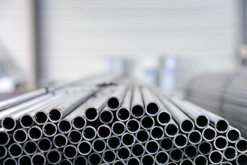 Close up of internal metal pipes in a warehouse. Stack of new and shiny steel pipe in factory....
