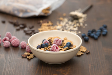 flakes with berries in brown bowl