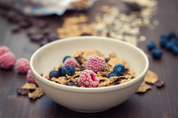 flakes with berries in brown bowl