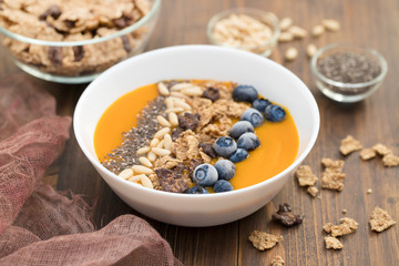 puree of mango with granola, chia and berries in white bowl