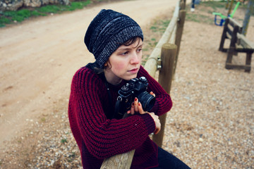Adolescente en una escena rural llevando su cámara 