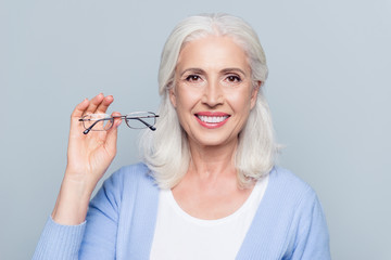 Old, charming, pretty woman showing glasses for sight, senior, people health care, standing over...