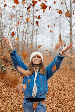 Retrato de chica lanzando hojas de oto&ntilde;o al aire
