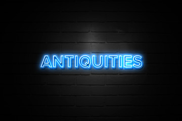 Antiquities neon Sign on brickwall