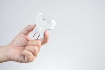 Hand holding wall LED light plug, and electric outlet