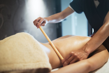 Masseur using massage bamboo sticks