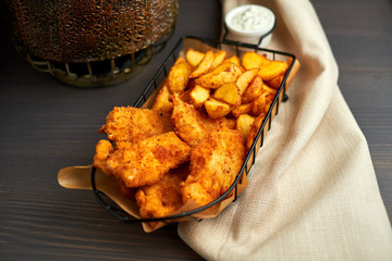 Nuggets and baked potatoes in a beautiful basket with white sauce