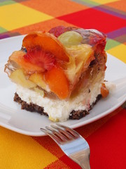 fruits cake on dish with fork and vivid worm color tablecloth
