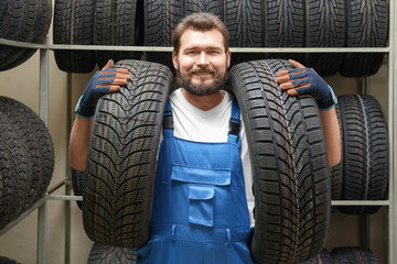 Male mechanic with car tires in automobile shop © Africa Studio