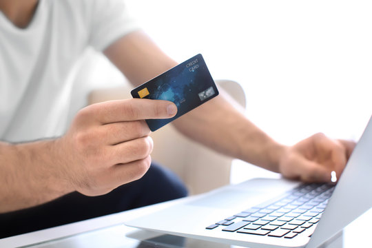 Man with credit card and laptop, closeup