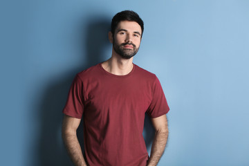 Young bearded man in casual clothes on color background