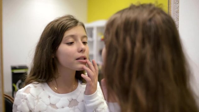 Girl Brunette Admires Itself Dry chapped lips In A Mirror