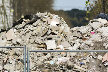a pile of debris on a construction site behind a blurred fence