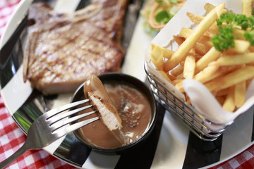 Close up the fork pick up steak and dipped in black pepper sauce