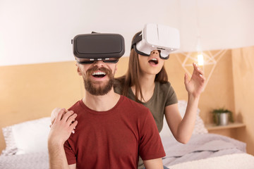 Emotional shock. Joyful merry sweet couple opening mouth while posing in VR glasses and looking up