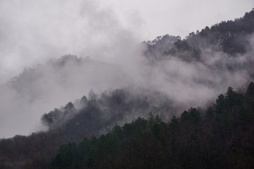 Fototapeta na wymiar Heavy fog rising from the Cerna Mountains near the resort town of Baile Herculane