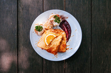 Top shot of beautiful French toast dish with orange honey sauce, strawberry jam, on old wooden table