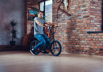A handsome man with BMX in a studio.
