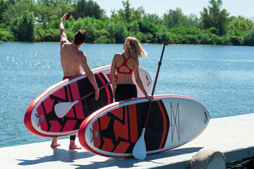 couple in love having fun on stand up paddle board SUP