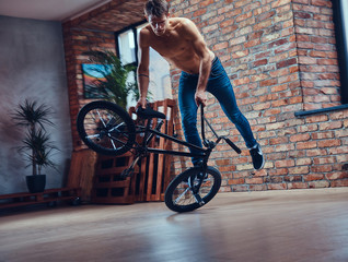 A handsome man with BMX in a studio.