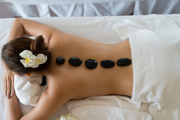 Young beautiful Asian woman relaxing in the Spa Stone Massage. Spa Hot Stones.
