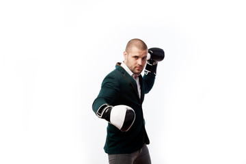 Naklejka premium Young bald man, confident business man in white shirt, green suit and boxing gloves doing an uppercut, boxing on white isolated background