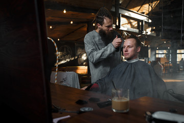 Obraz na płótnie Canvas Barber cutting hair of customer. Smal business