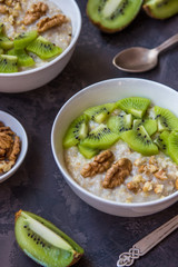 Oatmeal with kiwi fruit and walnuts. Two bowls porridge