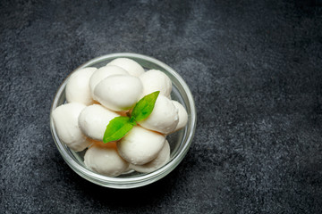 Traditional Italian Mozzarella cheese and basil on dark concrete