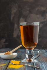 Tea, turmeric, honey and lemon on a wooden dark background