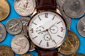 Clock with coins on a blue background