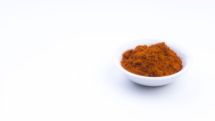 Red Chilly Powder in a bowl on white background. Selective focus and crop fragment.