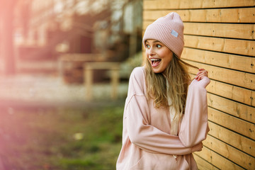 cool young woman in pink hoodie on wooden background - obrazy, fototapety, plakaty