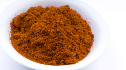 Red Chilly Powder in a bowl on white background. Selective focus and crop fragment.