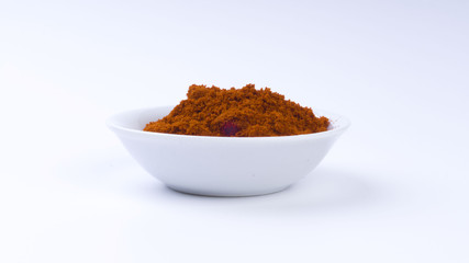 Red Chilly Powder in a bowl on white background. Selective focus and crop fragment.